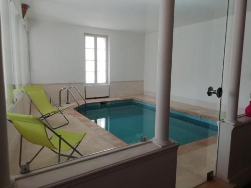 una piscina con una silla verde y una piscina en Les Colonnades, en Moussan