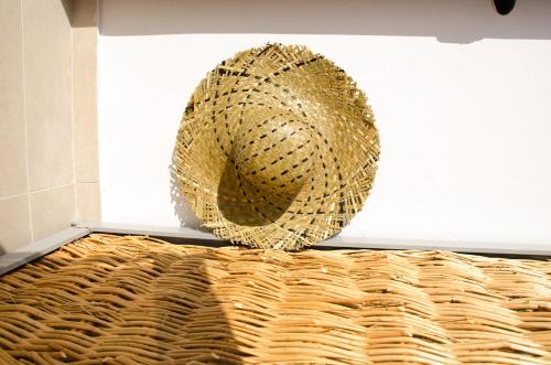 a straw hat sitting on top of a basket at Eleana Hotel in Tinos Town