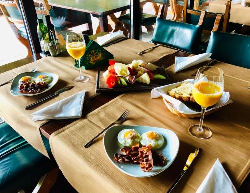 una mesa de madera con platos de comida y copas de vino en Boutique Hotel Casa Emil, en Poiana Brasov
