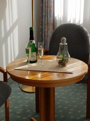 a table with two glasses and a bottle of wine at Smarthotel Gallmersgarten in Gallmersgarten