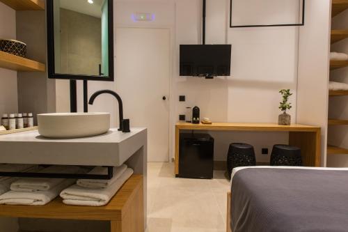 a bathroom with a sink and a bed at Eleana Hotel in Tinos Town