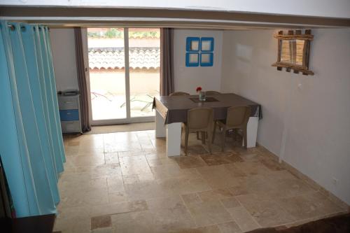 uma sala de jantar com uma mesa e cadeiras e uma janela em Appartement FredMart em Mougins