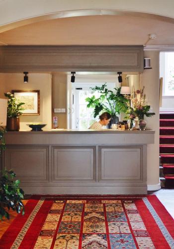 a woman standing behind a counter in a room at The Grosvenor Stockbridge in Stockbridge