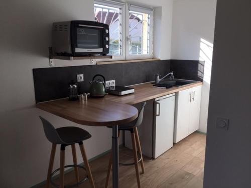 Il comprend une petite cuisine avec une table et une télévision murale. dans l'établissement 87 Rue du 8ème Zouaves, à Rémelfing