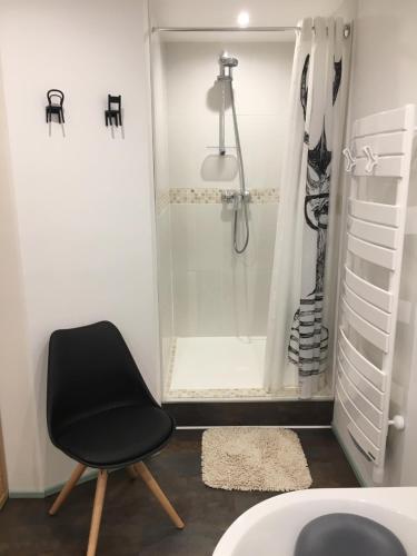 - une chaise noire dans la salle de bains pourvue d'une douche dans l'établissement 87 Rue du 8ème Zouaves, à Rémelfing
