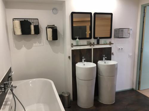 La salle de bains est pourvue de 2 lavabos, d'une baignoire et de miroirs. dans l'établissement 87 Rue du 8ème Zouaves, à Rémelfing