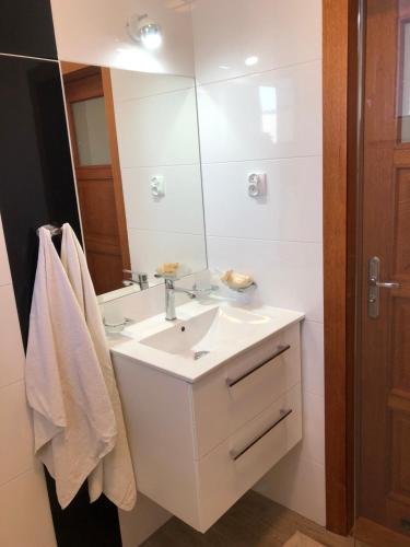 a white bathroom with a sink and a mirror at Willa Perła Morza in Władysławowo