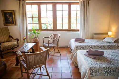 une chambre avec deux lits, une table et des chaises dans l'établissement Domaine de Perruche du buis, à Arques