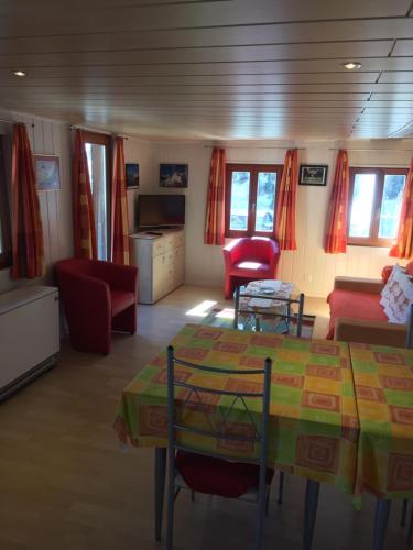 a living room with a table and red chairs at Appartement Beauchocty in Evolène