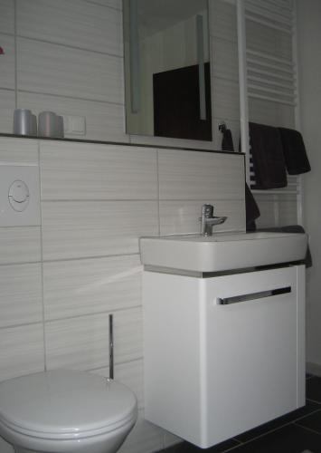 a bathroom with a white sink and a toilet at Ferienwohnung Schneemann in Hohegeiß