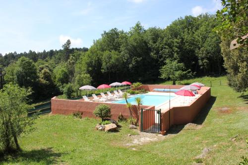 une piscine avec chaises et parasols dans une cour dans l'établissement Domaine de Perruche du buis, à Arques