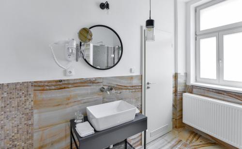 a bathroom with a sink and a mirror on the wall at Hotel Garden Court in Prague