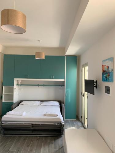 - une chambre avec un lit et un mur bleu dans l'établissement Casa Vacanze B&B Uccialì, à Le Castella