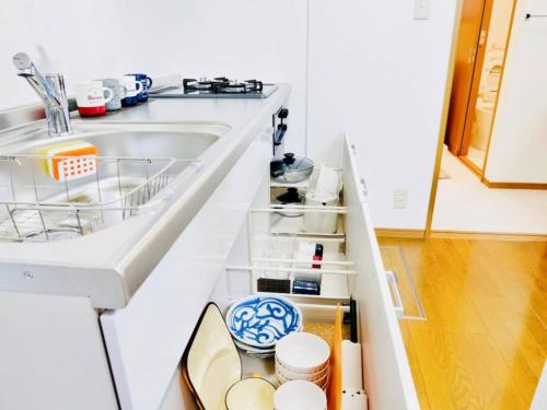 a kitchen counter with an open drawer with dishes at Triphome Ikebukuro Tokyo Max 7ppls FREE WIFI in Tokyo