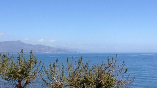 a large body of water with a mountain in the background at Torre Archirafi Vacanze in Riposto