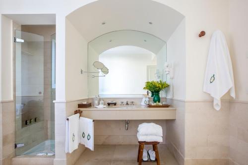 y baño con lavabo y ducha con espejo. en Masseria San Domenico en Savelletri