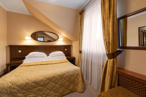 a hotel room with a bed and a mirror at Spa Hotel Mistral- Apartments in Rozhdestveno