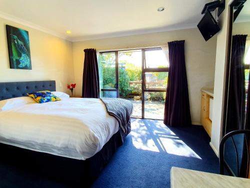 a bedroom with a bed and a large window at Te Mahuru Retreat in Kaikoura