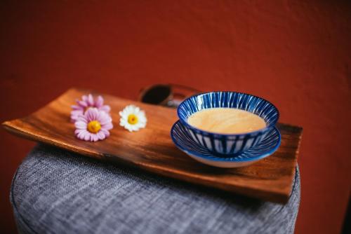 una bandeja de madera con un tazón y flores. en EM Kastelo Zadar, en Zadar