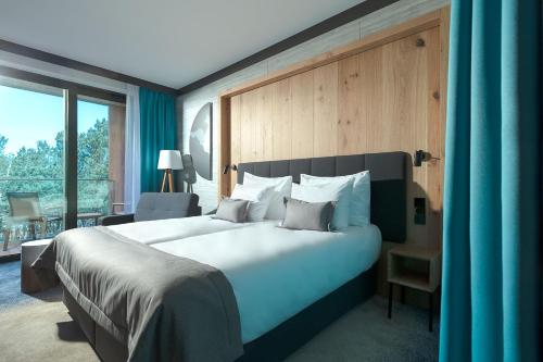 sypialnia z dużym łóżkiem i dużym oknem w obiekcie Gwiazda Morza Resort SPA&SPORT we Władysławowie