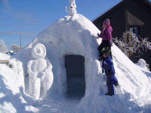a child standing on top of a snow igloo at Apartment Johanna Oberhof in Oberhof