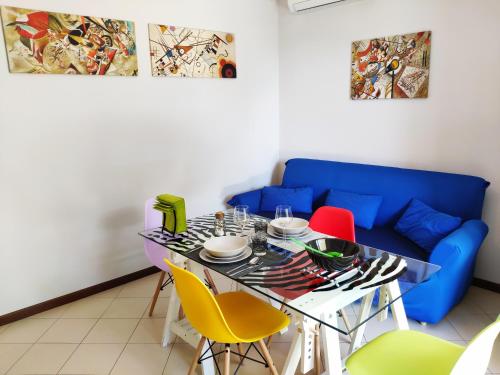 una sala da pranzo con divano blu e tavolo con sedie di Bed & Smile a Valeggio sul Mincio