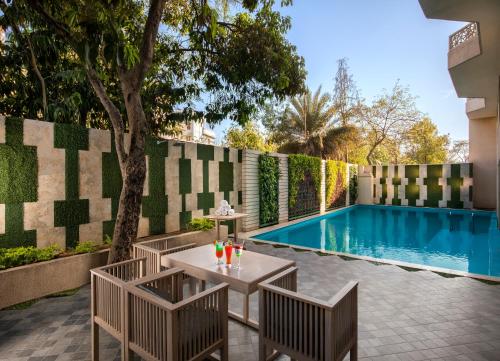 a patio with a table and chairs next to a swimming pool at Sarovar Premiere Jaipur in Jaipur