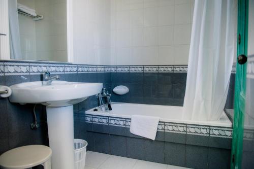 a bathroom with a sink and a tub and a toilet at Hotel Torre Cristina in Noja