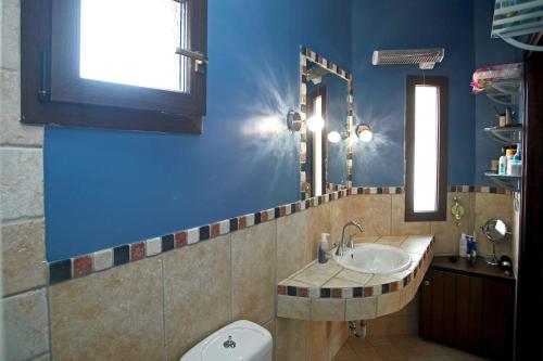 een badkamer met een wastafel, een toilet en een spiegel bij Beautiful Studio in traditional Afytos Halkidiki-UVC sterilized in Afitos