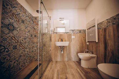 a bathroom with a toilet and a sink and a shower at Le canne Pool and Relax in Pulsano