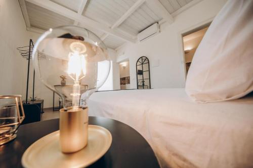 a lamp on a table next to a bed at Le canne Pool and Relax in Pulsano