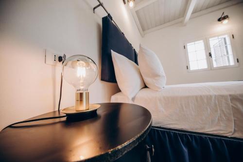 a bedroom with a bed and a table with a lamp at Le canne Pool and Relax in Pulsano