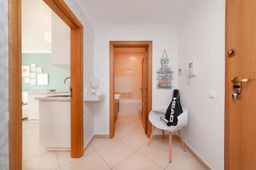 a bathroom with a sink and a toilet and a chair at Oura BlueSea Apartment in Albufeira