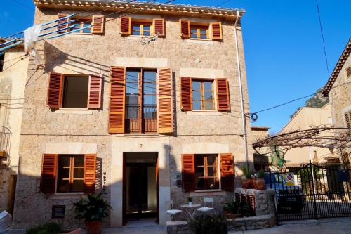 an old building with brown shutters on it at Marton Hotel Valldemossa in Valldemossa