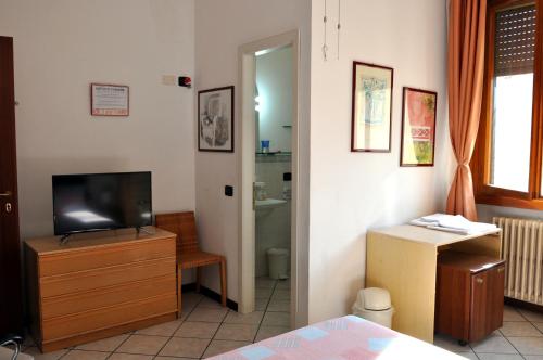 フィレンツェにあるAffittacamere Beaのテレビ、ドレッサー、バスルームが備わる客室です。