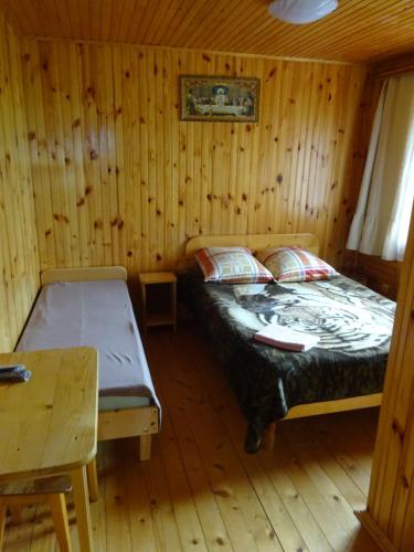 ein Schlafzimmer mit einem Bett in einer Holzhütte in der Unterkunft Біля лісу Апартименти з двома спальнями in Slawske