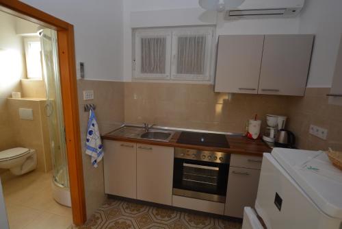 a small kitchen with a sink and a stove at Apartment Nadica in Punat