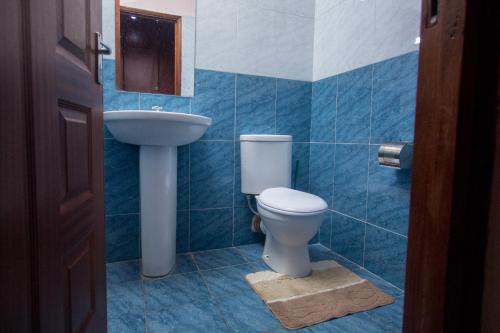 a bathroom with a toilet and a sink at Furnished Homes Nakuru with pool & GYM in Nakuru