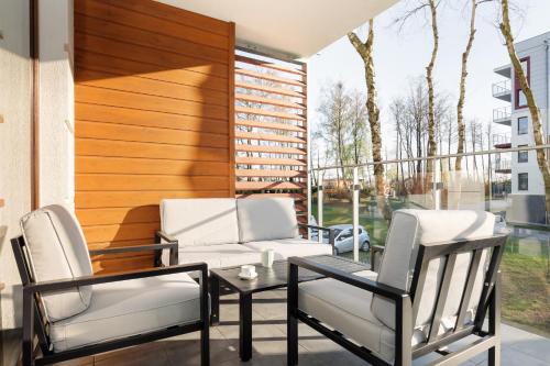 a patio with two chairs and a table and a couch at Apartamenty Osiedle Polanki by Renters in Kołobrzeg