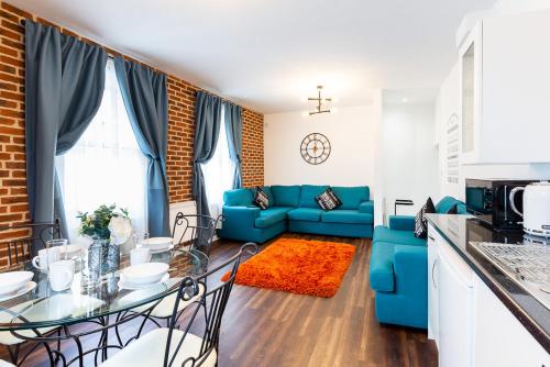 ein Wohnzimmer mit einem blauen Sofa und einem Tisch in der Unterkunft Honeypot House in Newcastle upon Tyne