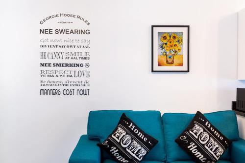 Sofá azul en una sala de estar con pared en Honeypot House, en Newcastle