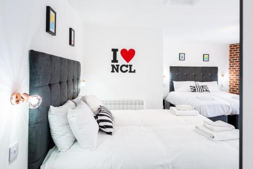 a bedroom with two beds with white pillows at Honeypot House in Newcastle upon Tyne
