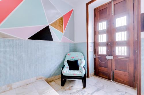 a chair in a room with a door at À da Avó -The Guesthouse in Faro