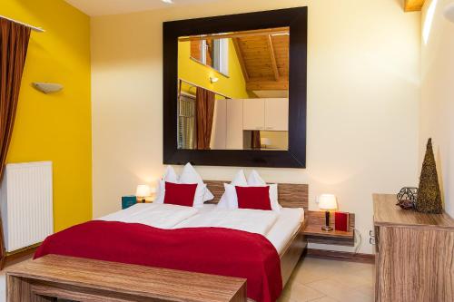 a bedroom with a large bed and a mirror at Hotel Garni Pölzl in Deutschlandsberg