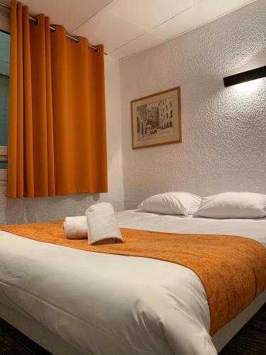 - une chambre avec 2 lits et un rideau orange dans l'établissement Hotel de Bretagne, à Lyon