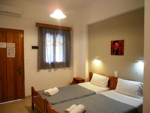 a hotel room with two beds and a window at Anemona Studios in Paleokastritsa