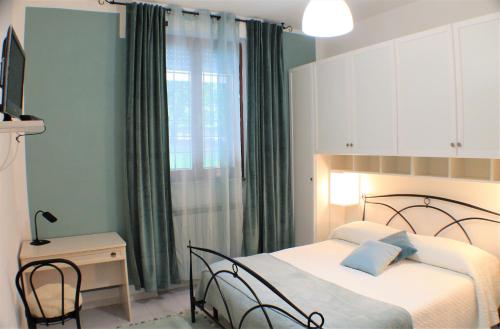 una camera con due letti e una finestra con tende verdi di appartamento via ciatti a Perugia