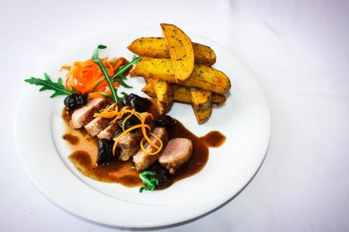 a plate of food with meat and french fries at Wellness Hotel Staré Město in Uherské Hradiště