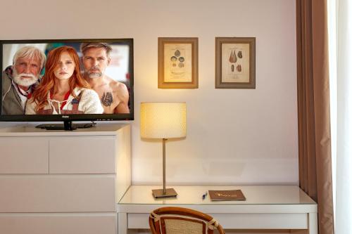 una TV seduta su un comò in una stanza di Hotel Esplanade a Marina di Pietrasanta