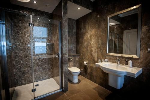 a bathroom with a shower and a sink and a toilet at Seamill Hydro Hotel in Seamill